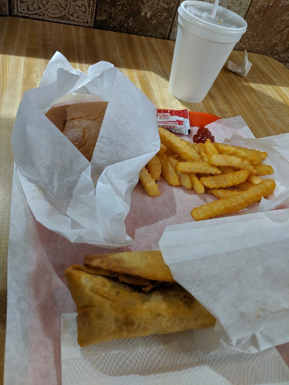Pastrami sandwich with fries and a drink.